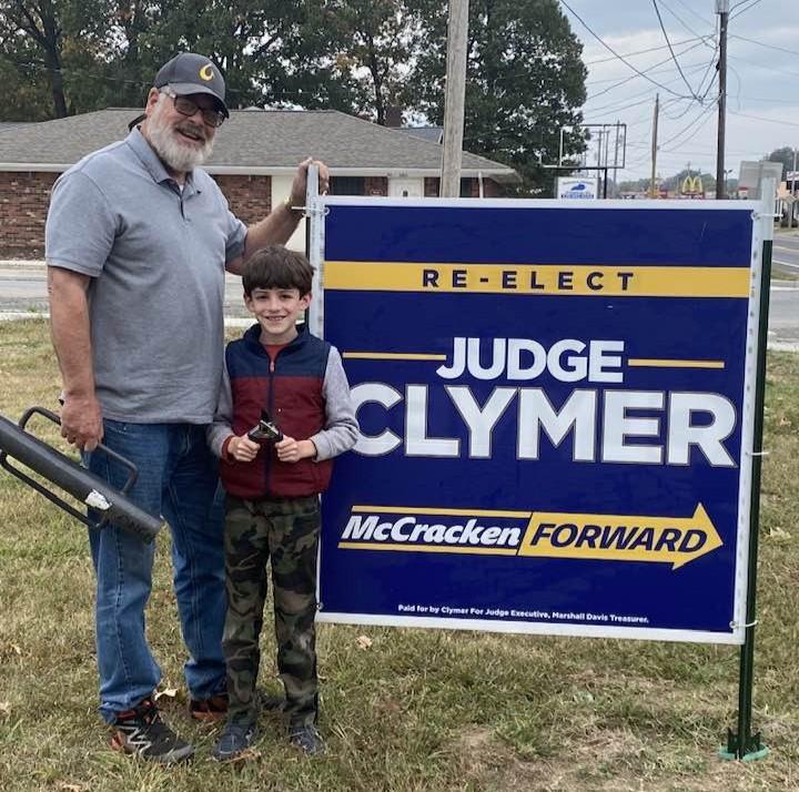 Re-elect Craig Clymer for McCfracken County Judge Executive sign with Craig Clymer and grandson